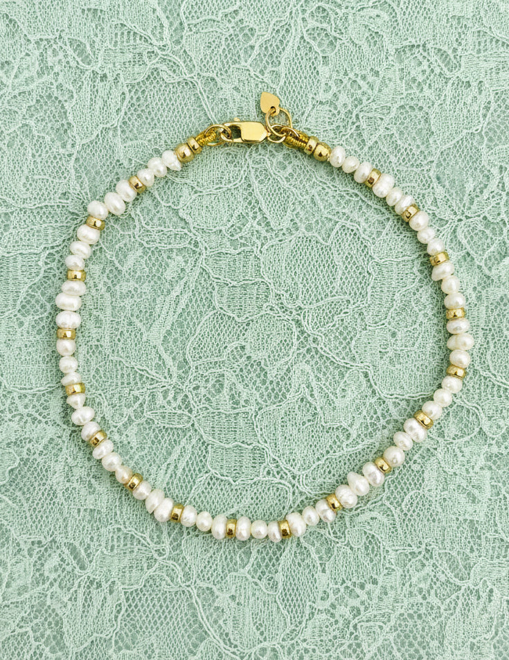 Freshwater Pearl bracelet with gold filled rondelles and clasp on a green background