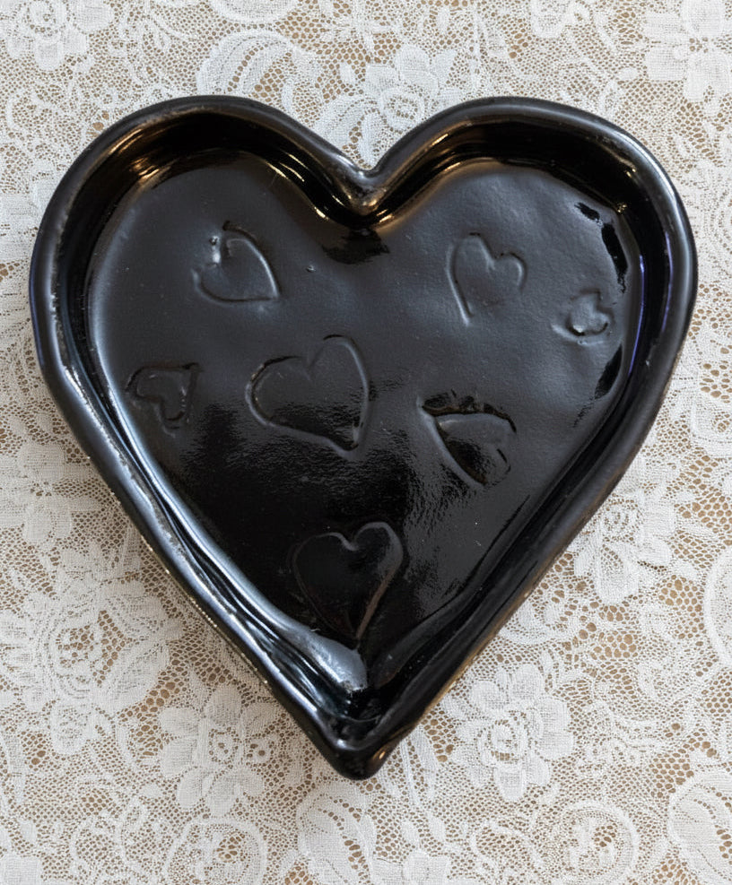 Black heart-shaped ceramic jewellery dish with embossed hearts on a lace background
