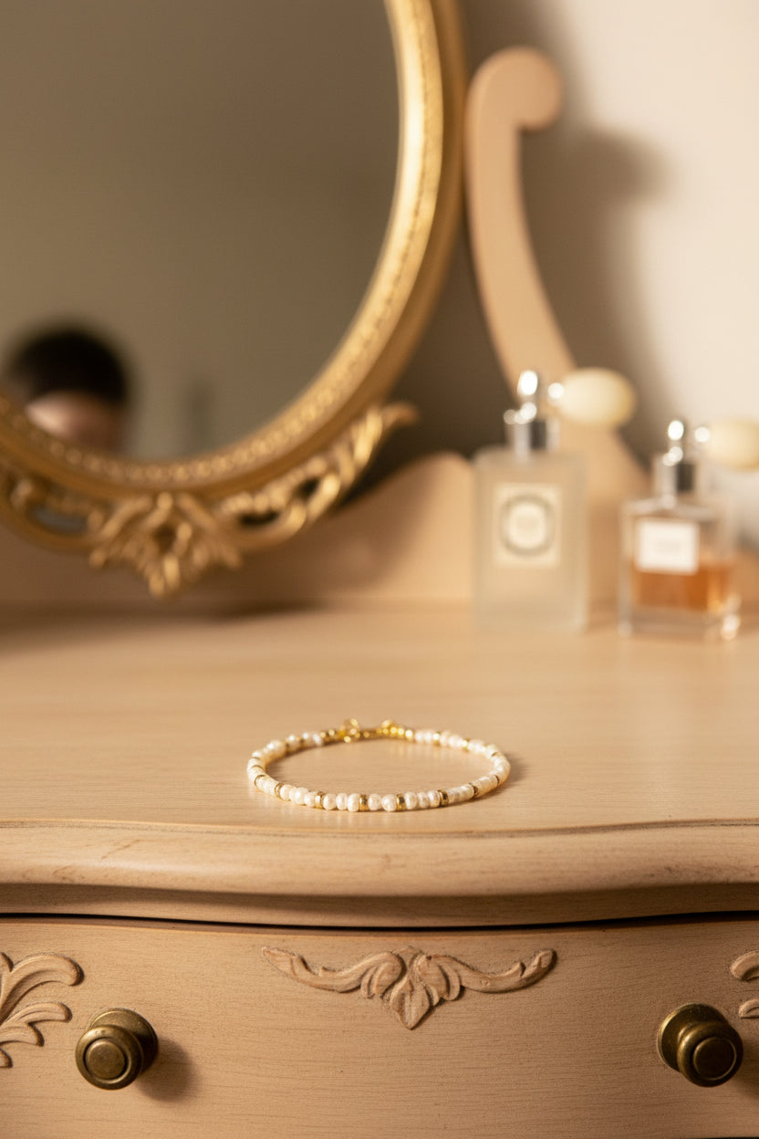 Pearl bracelet with gold clasp on a romantic dresser