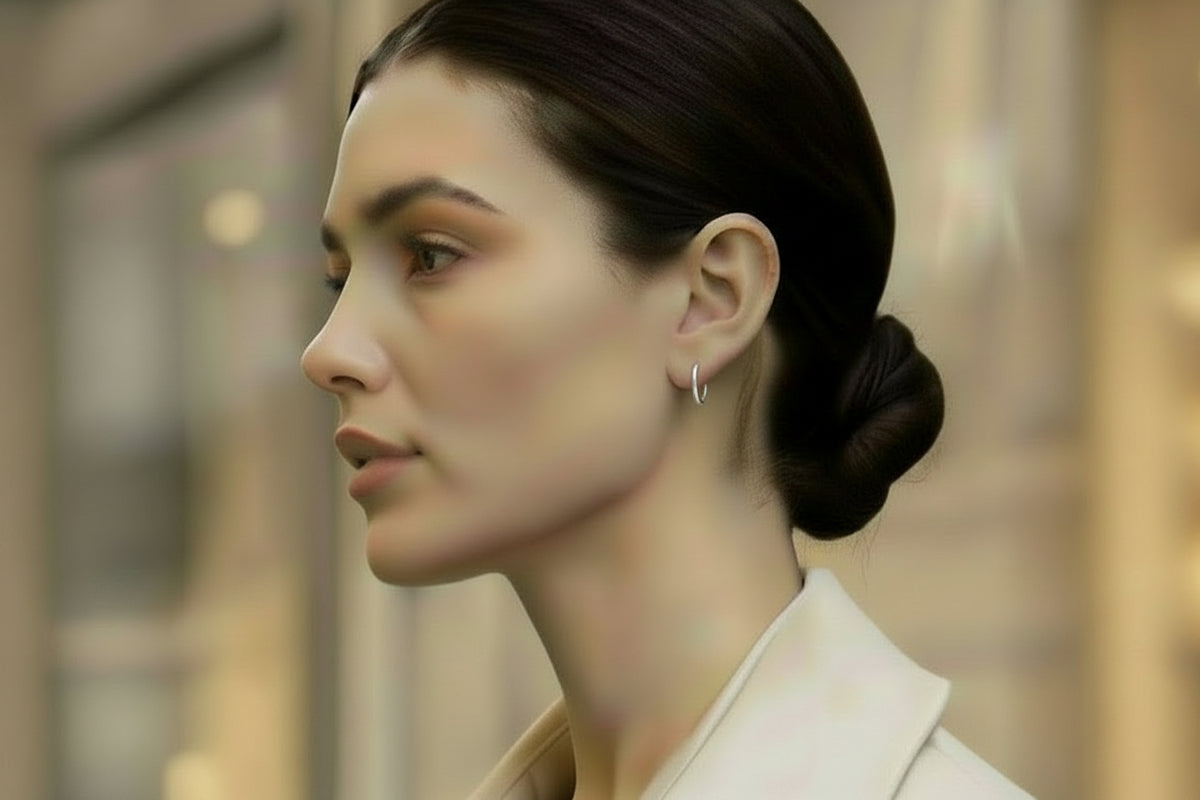 A closeup of a chic woman wearing meg huggies in a beige suit with a city street background