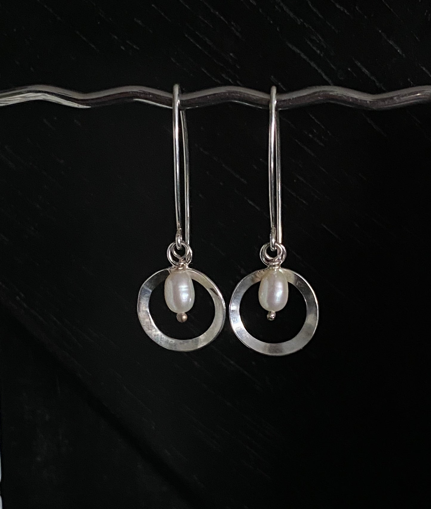 Deco inspired elegant silver circle adorned with a freshwater pearl in the centre, hanging on bespoke ear wires