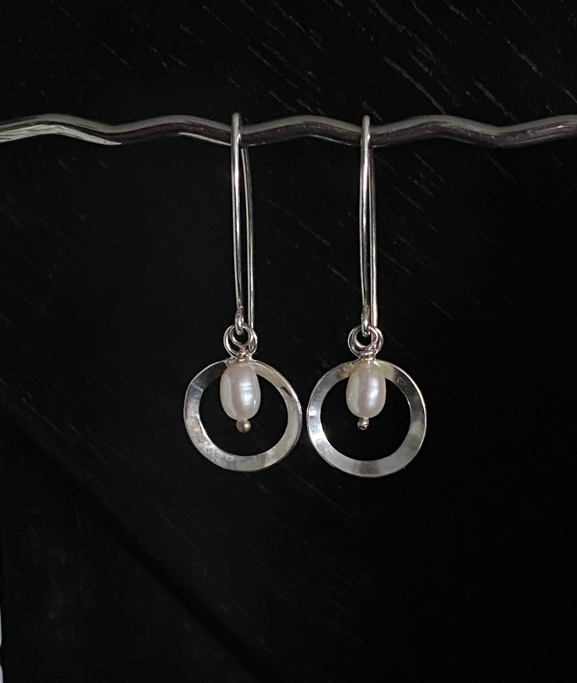 Deco inspired elegant silver circle adorned with a freshwater pearl in the centre, hanging on bespoke ear wires
